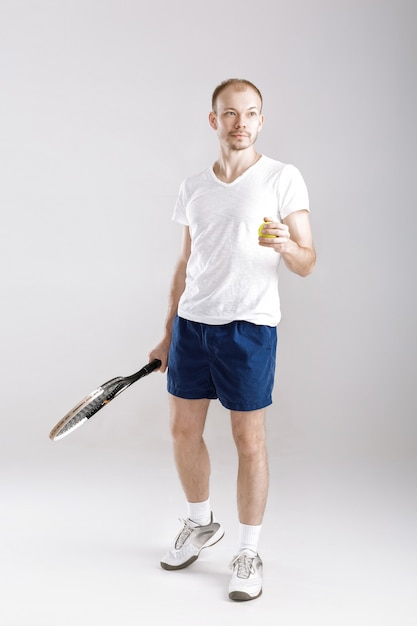 Joven tenista juega al tenis en un gris