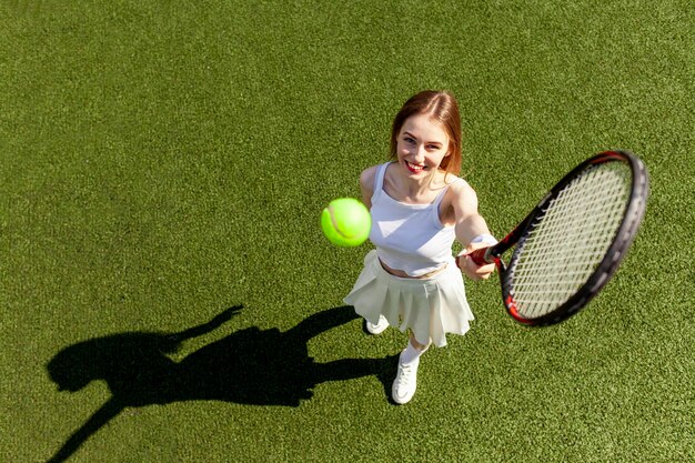 joven tenista con uniforme deportivo blanco juega tenis en una cancha verde entrenadora de tenis