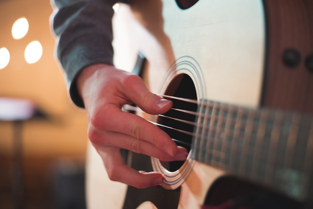 Joven tocando la guitarra acústica