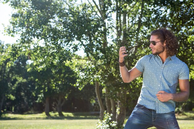 Joven tocando la guitarra de aire en el parque