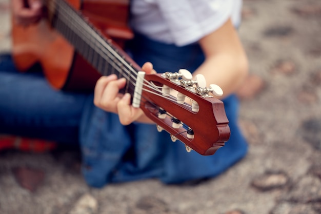 Foto joven tocando la guitarra al aire libre