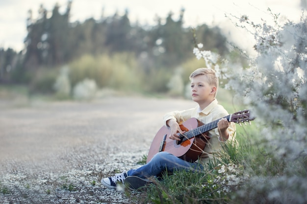 Joven tocando la guitarra al aire libre