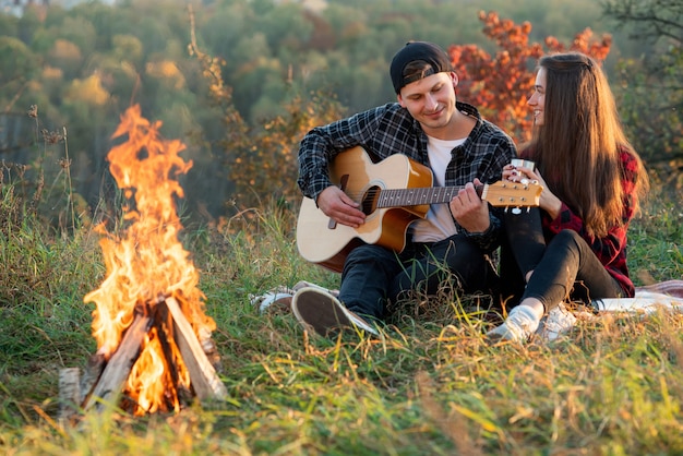 Joven tocando la guitarra para su novia encantadora