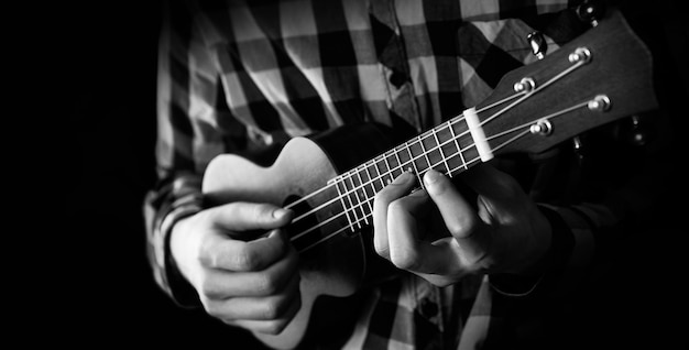 Un joven tocando el ukelele en vista cercana