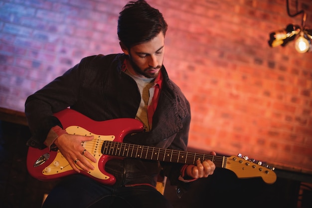 Joven, tocar la guitarra