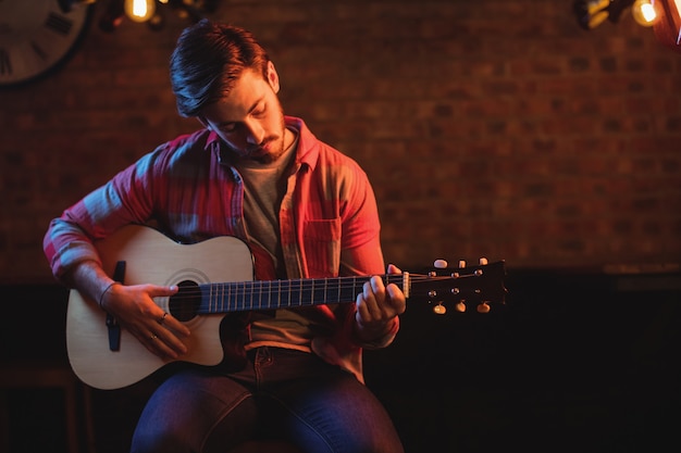 Joven, tocar la guitarra