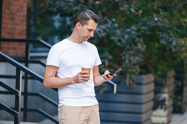 Joven tomando café en la ciudad al aire libre