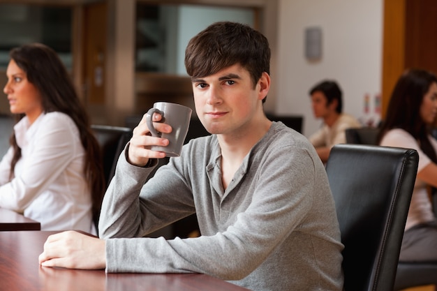 Joven tomando un café