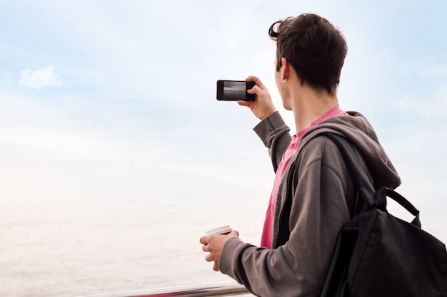 Joven tomando una foto con un teléfono móvil