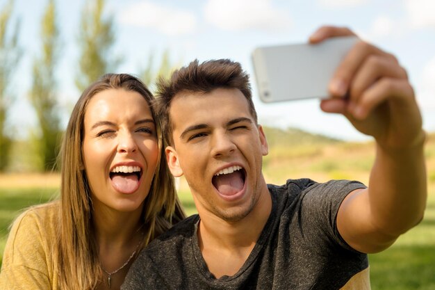 Foto un joven tomando una selfie con una mujer en el teléfono móvil