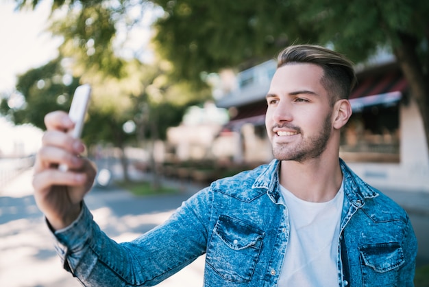 Foto joven tomando selfies con teléfono.