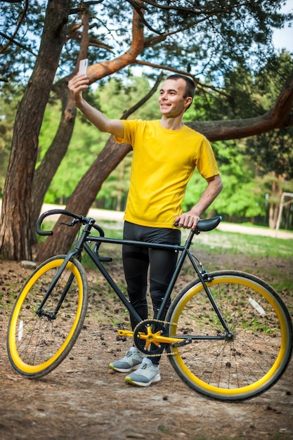 Un joven tomándose un selfie con su bicicleta