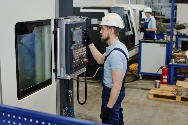 Joven torneador profesional que utiliza una máquina CNC