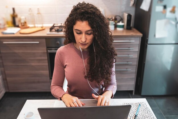 Una joven trabaja desde casa en la computadora durante las restricciones debido a la pandemia de COVID-19