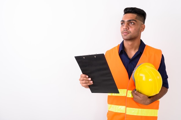 Joven trabajador de la construcción indio en blanco