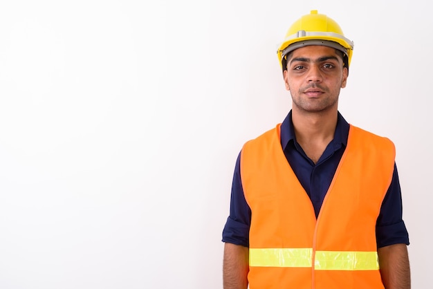 Joven trabajador de la construcción indio en blanco