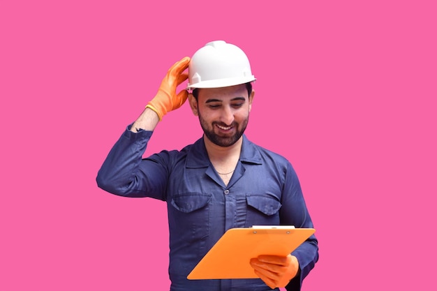 Joven trabajador de la construcción sonriendo sosteniendo el portapapeles modelo paquistaní indio