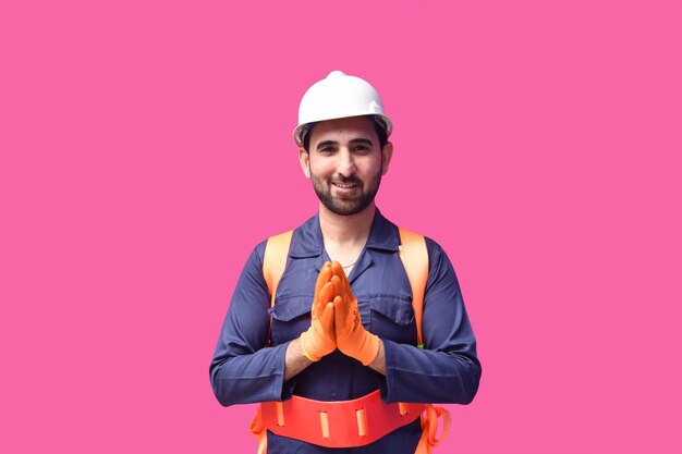 Joven trabajador de la construcción sonriendo y usando el cinturón de seguridad y mirando al frente modelo paquistaní indio