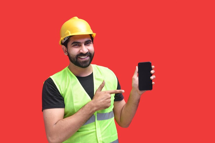 Foto joven trabajador de construcción sosteniendo el teléfono y apuntando hacia el modelo paquistaní indio