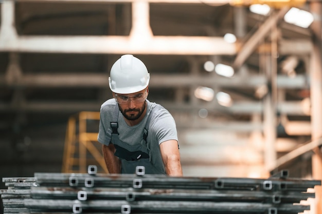 Foto joven trabajador de fábrica con uniforme gris