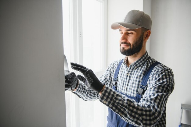 Foto joven trabajador haciendo reparaciones en la habitación