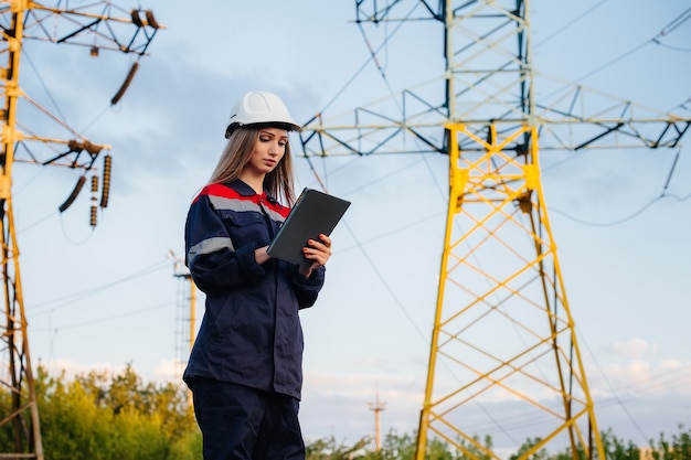 Un joven trabajador de ingeniería inspecciona y controla el equipo de la línea eléctrica. Energía.