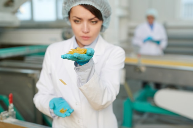 Joven trabajador inspeccionando macarrones