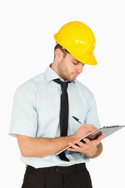 Foto joven trabajador líder escribiendo en su portapapeles