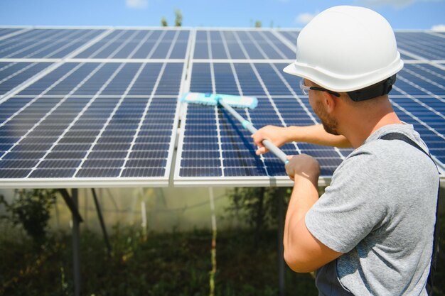 Joven trabajador limpiando paneles solares