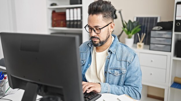 Joven trabajador de negocios latino que usa computadora trabajando en la oficina