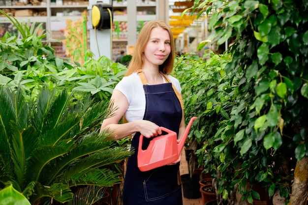 Joven trabajador pelirrojo en el mercado de plantas