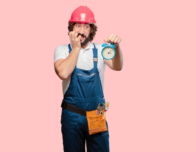 Joven trabajador con un reloj despertador