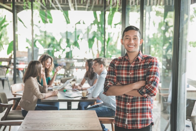 Joven trabajador reunido en un café con su trabajo en equipo