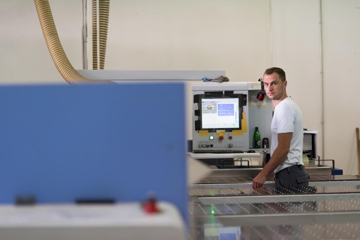 Foto joven trabajador trabaja en una fábrica para la producción de muebles de madera.