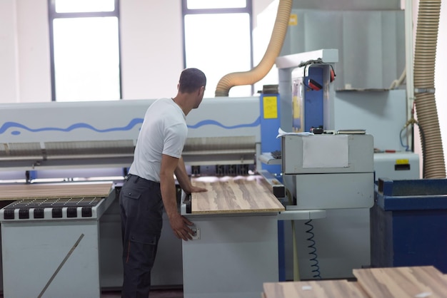 Joven trabajador trabaja en una fábrica para la producción de muebles de madera.