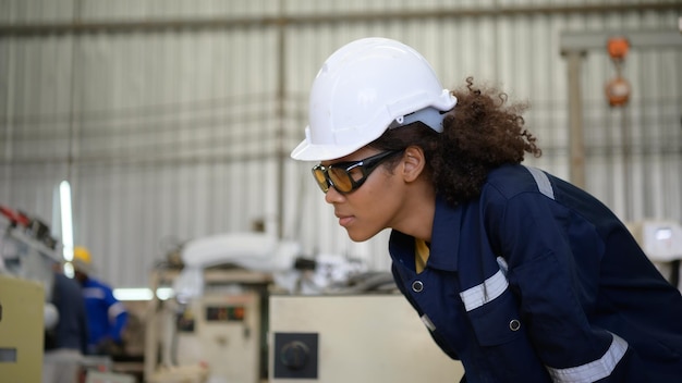 Una joven trabajadora está controlando un robot mecánico