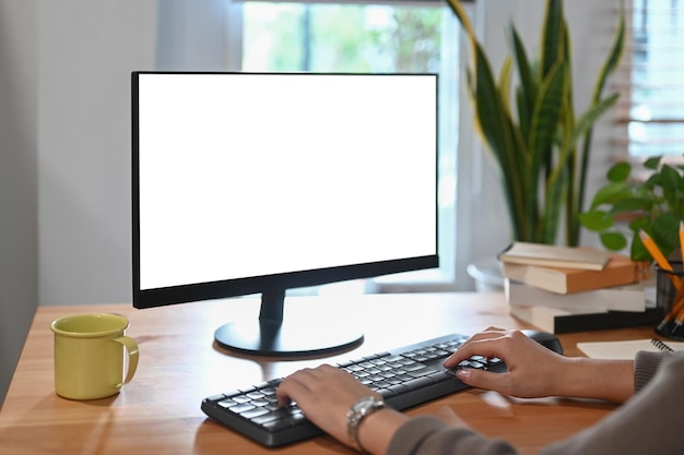 Foto joven trabajadora independiente que trabaja con una computadora en una oficina doméstica moderna