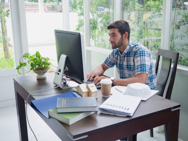 Joven trabajando en casa con café y periódico