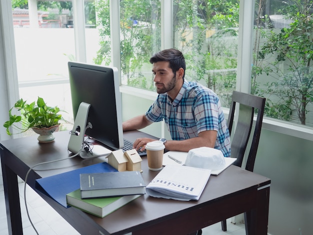 Joven trabajando en casa con café y periódico