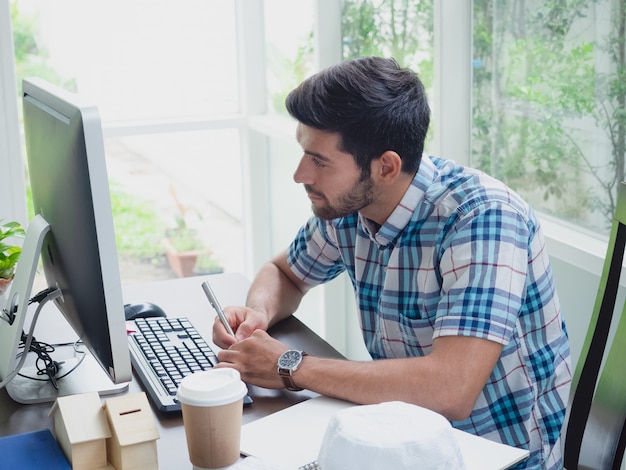 Joven trabajando en casa con café y periódico