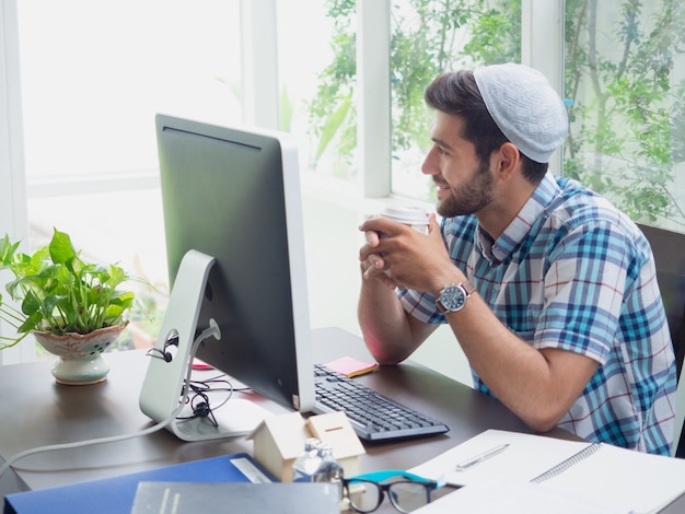 Joven trabajando en casa con café