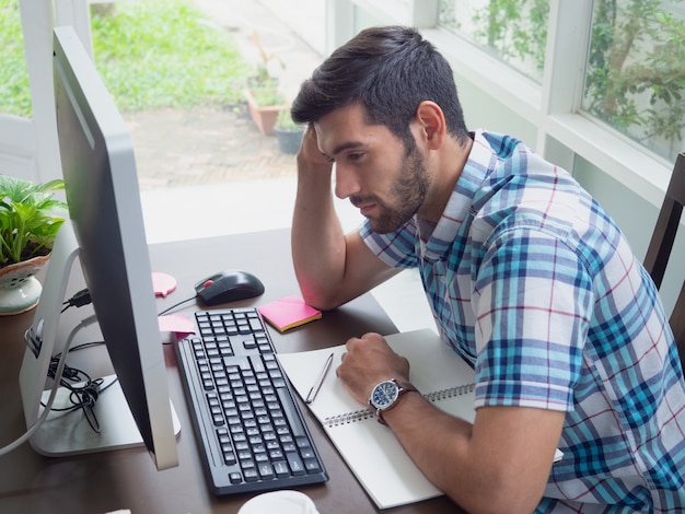 Joven trabajando en casa y estresado por el trabajo