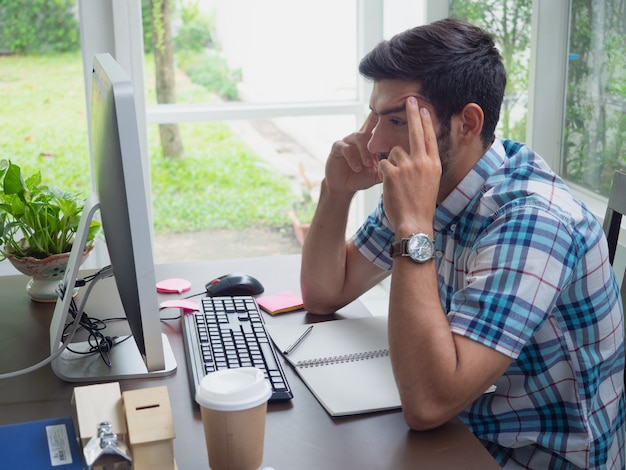 Joven trabajando en casa y pensando en algo