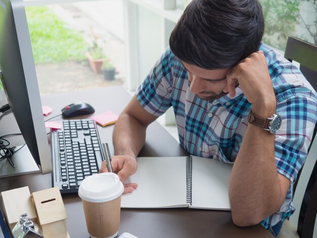 Joven trabajando en casa y pensando en algo