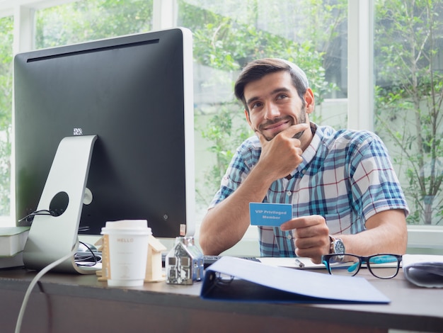 Joven trabajando en casa con tarjeta de seguro de salud