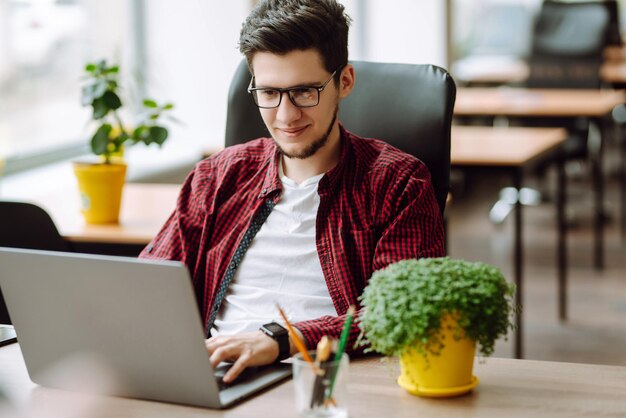 Joven trabajando en una computadora portátil Educación y trabajo en línea Trabajo remoto de tecnología independiente