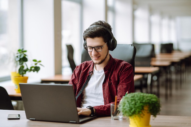 Joven trabajando en una computadora portátil Educación y trabajo en línea Trabajo remoto de tecnología independiente
