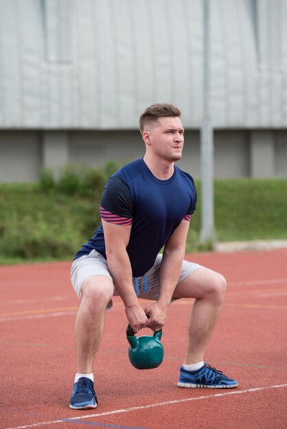 Joven trabajando con Kettle Bell ejercicio al aire libre