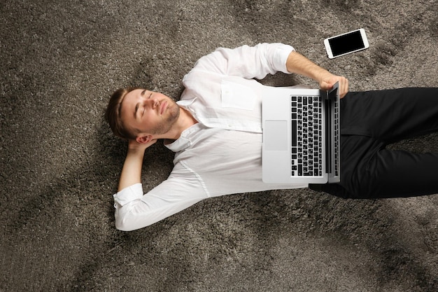 Joven trabajando con una laptop en el piso