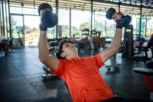 Foto joven trabajando con pesas en el gimnasio